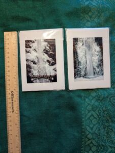 Aerial shot looking down on two photonotecards featuring frozen Multnomah Falls. The upper falls with the Benson bridge is on the left, the lower falls on the right. A wooden ruler shows on the left for scale.